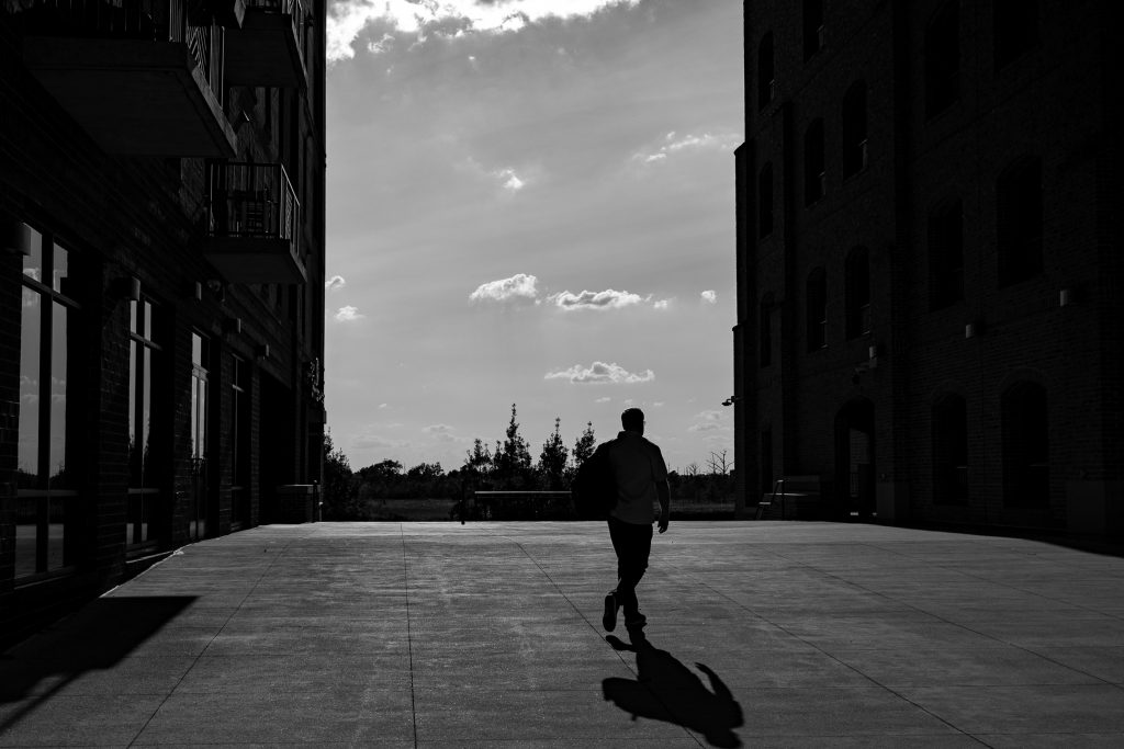 A man walks across the sidewalk in Bijou Park, Wilmington, NC.