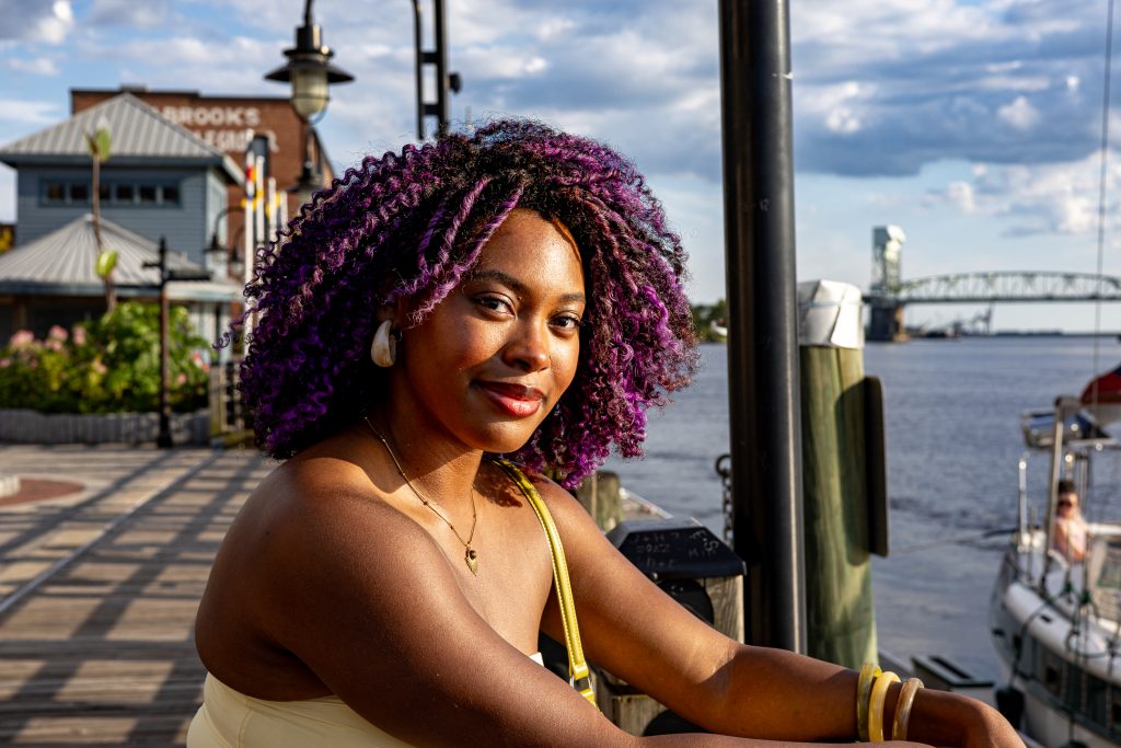 A woman sits by the edge of the Cape Fear River in downtown Wilmington, NC.
