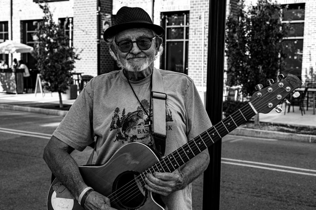 A shot of the Peanut Man and his guitar, edited in black and white.