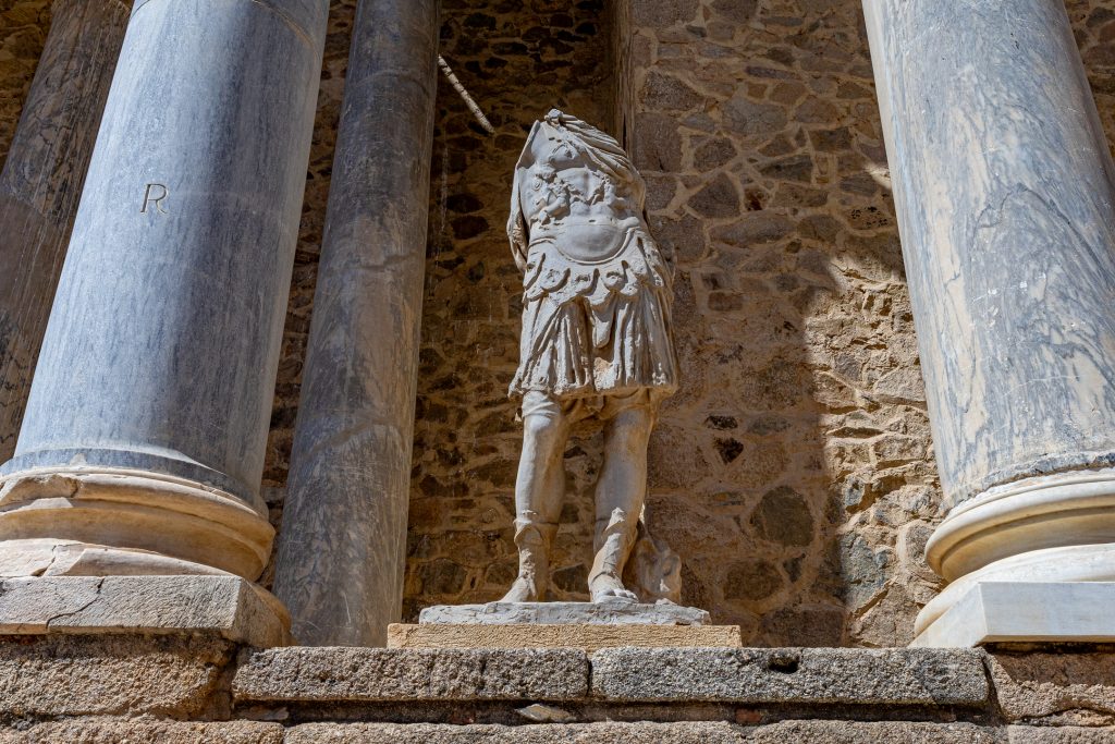 A headless and armless statue stands in the backdrop of the theater.