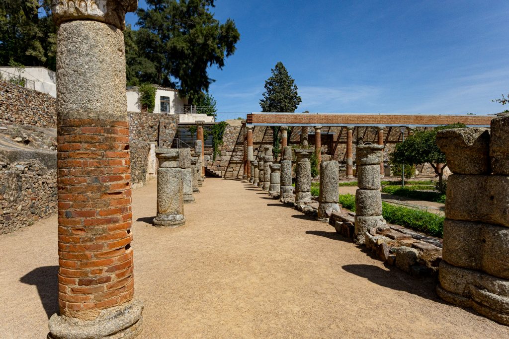 The remains of ancient columns line the walkway in the ornamental gardens near the Roman theater.